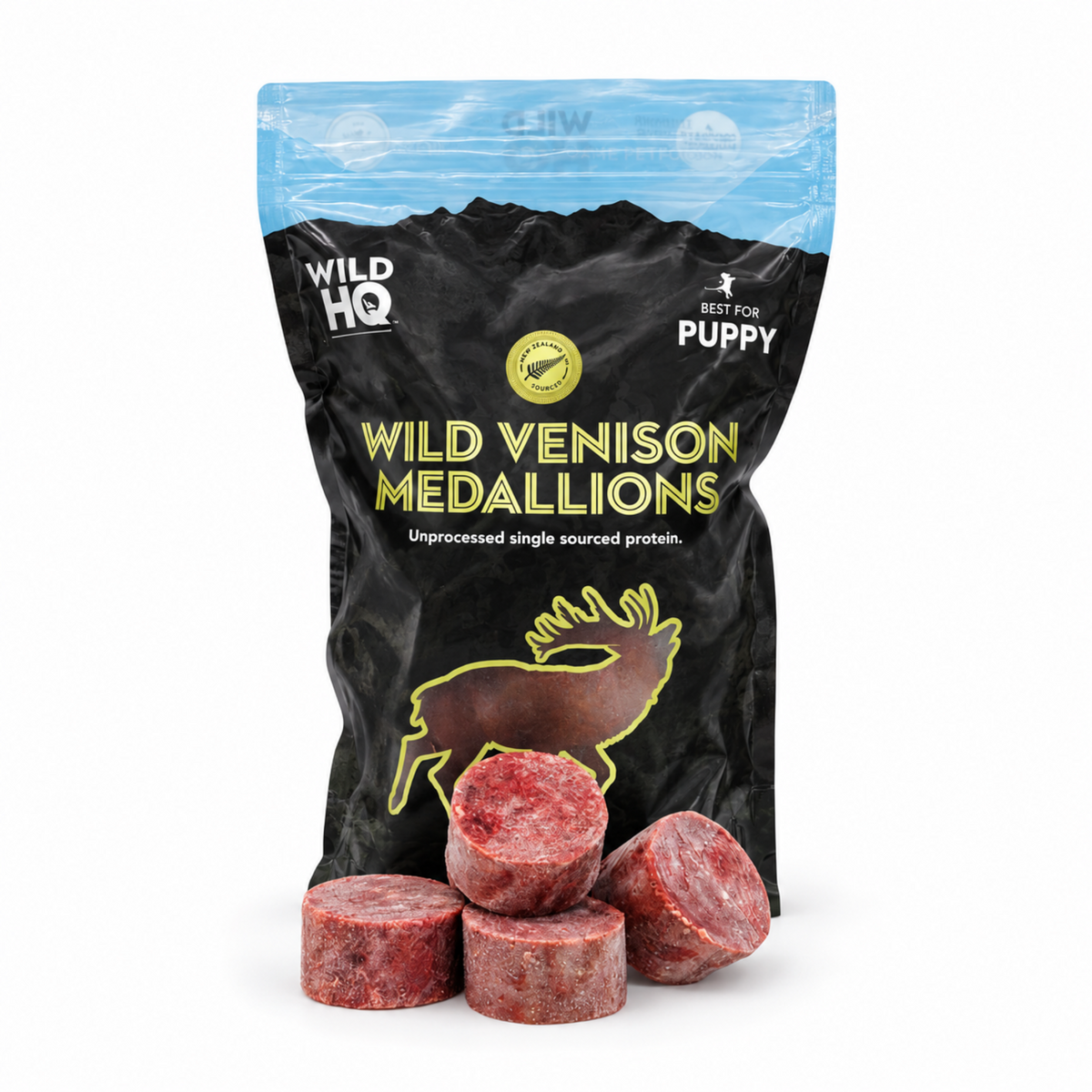 A black stand-up pouch of Wild HQ Wild Venison Medallions for puppies, with several pinkish-red freeze-dried meat medallions displayed in front on a white background.