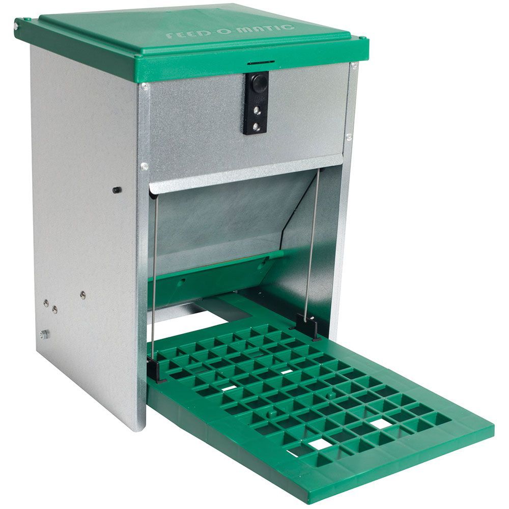A poultry feeder with a green and gray body, featuring a step plate and a shutter mechanism.